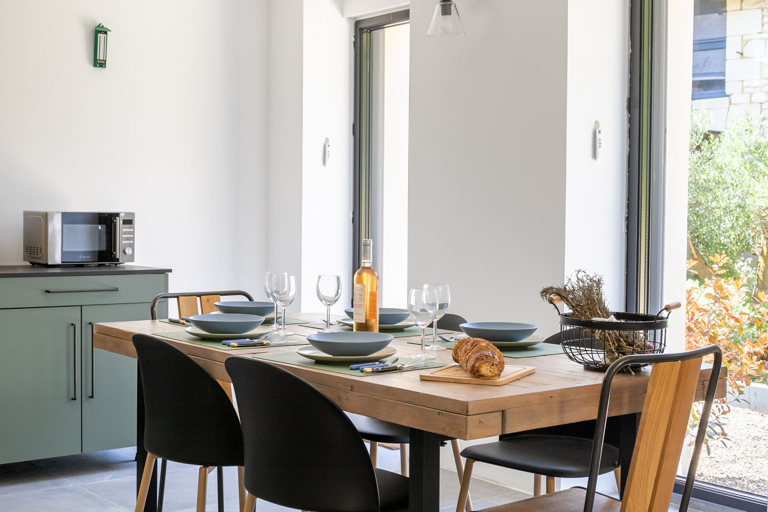 Table de salle à manger dressée, ouverte sur le jardin