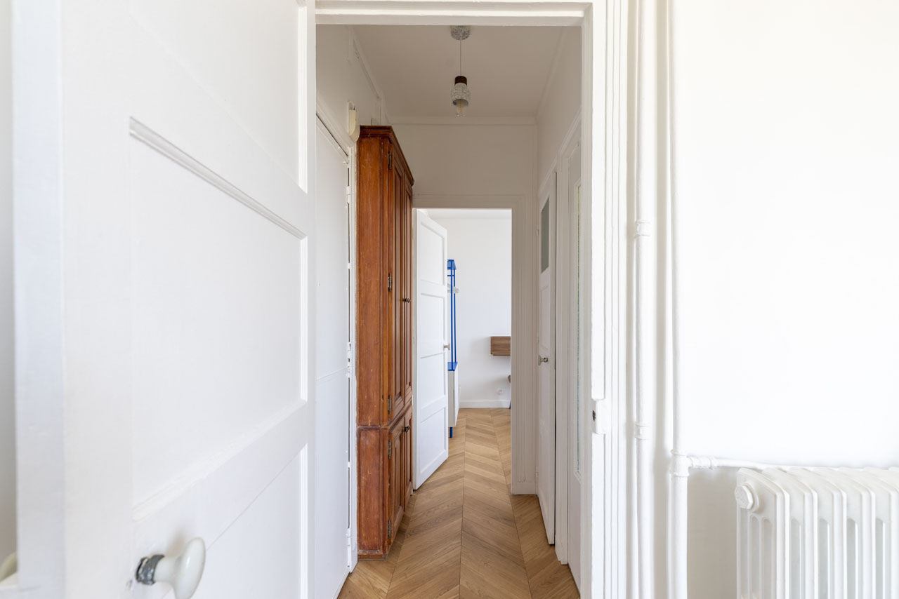 Entrée et couloir en parquet à chevrons desservant les pièces