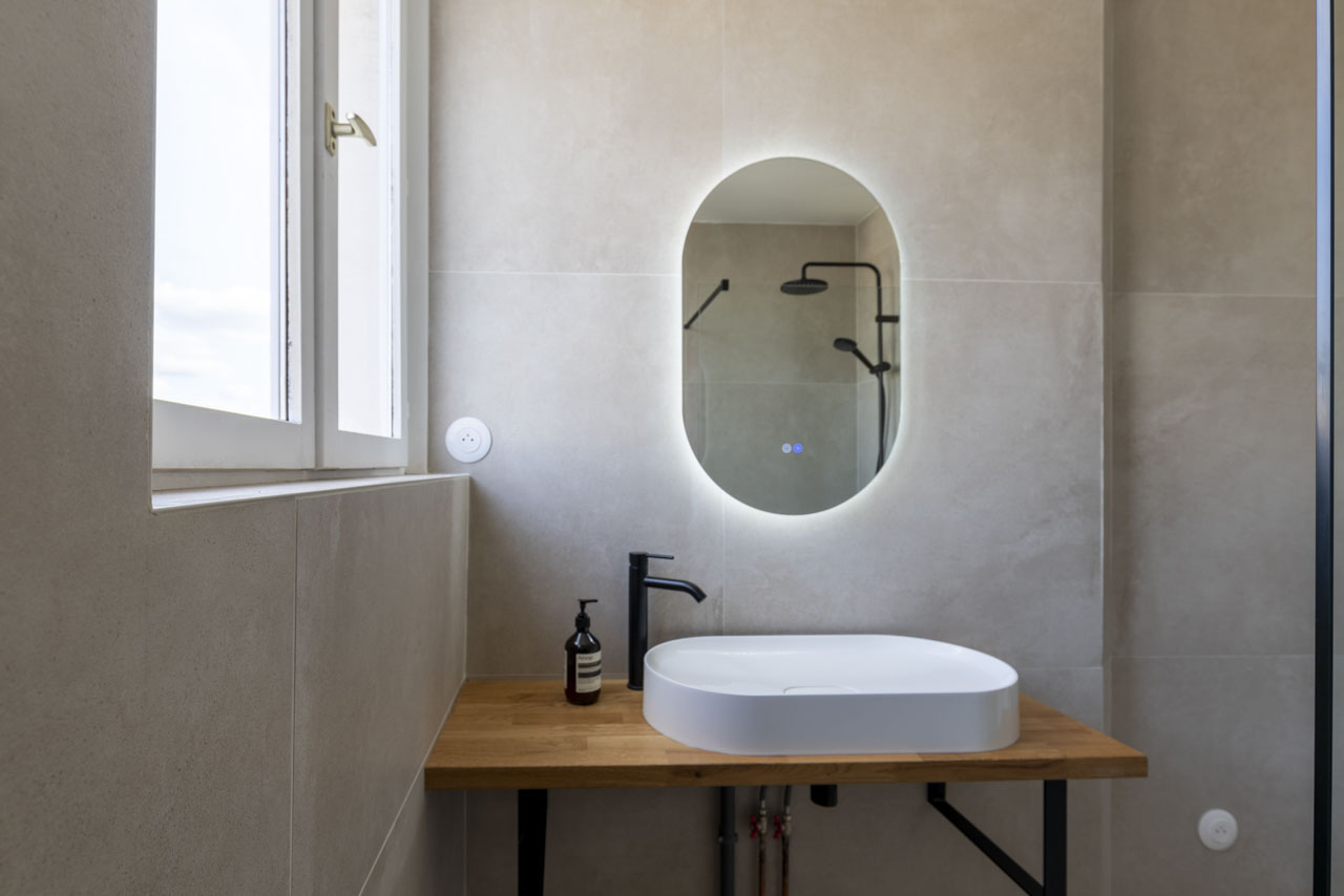 Salle de bain rénovée : vasque sur plan bois et miroir rétroéclairé
